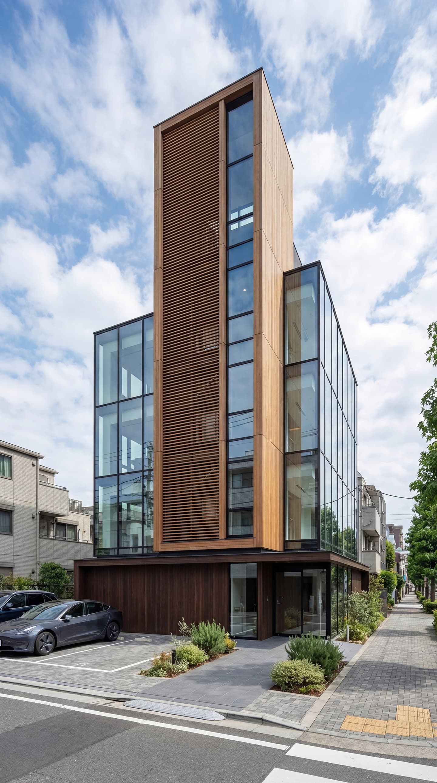 生成AIによる外観パース作成事例：青空の下、都市部の角地に建つモダンな5階建てビルの外観パース。明るい縦格子の木製ルーバーと、側面全面のガラスカーテンウォールが特徴的。1階にはエントランスと植栽があり、手前には駐車場がある。