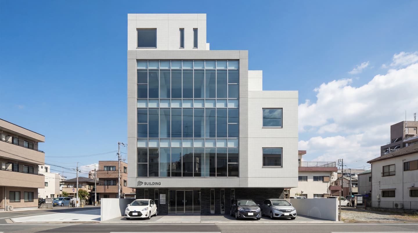 青空の下に建つ、モダンな5階建てオフィスビルの外観パース。白い外壁タイルと大きなガラス窓が特徴で、1階部分には駐車場と数台の乗用車が配置されている。